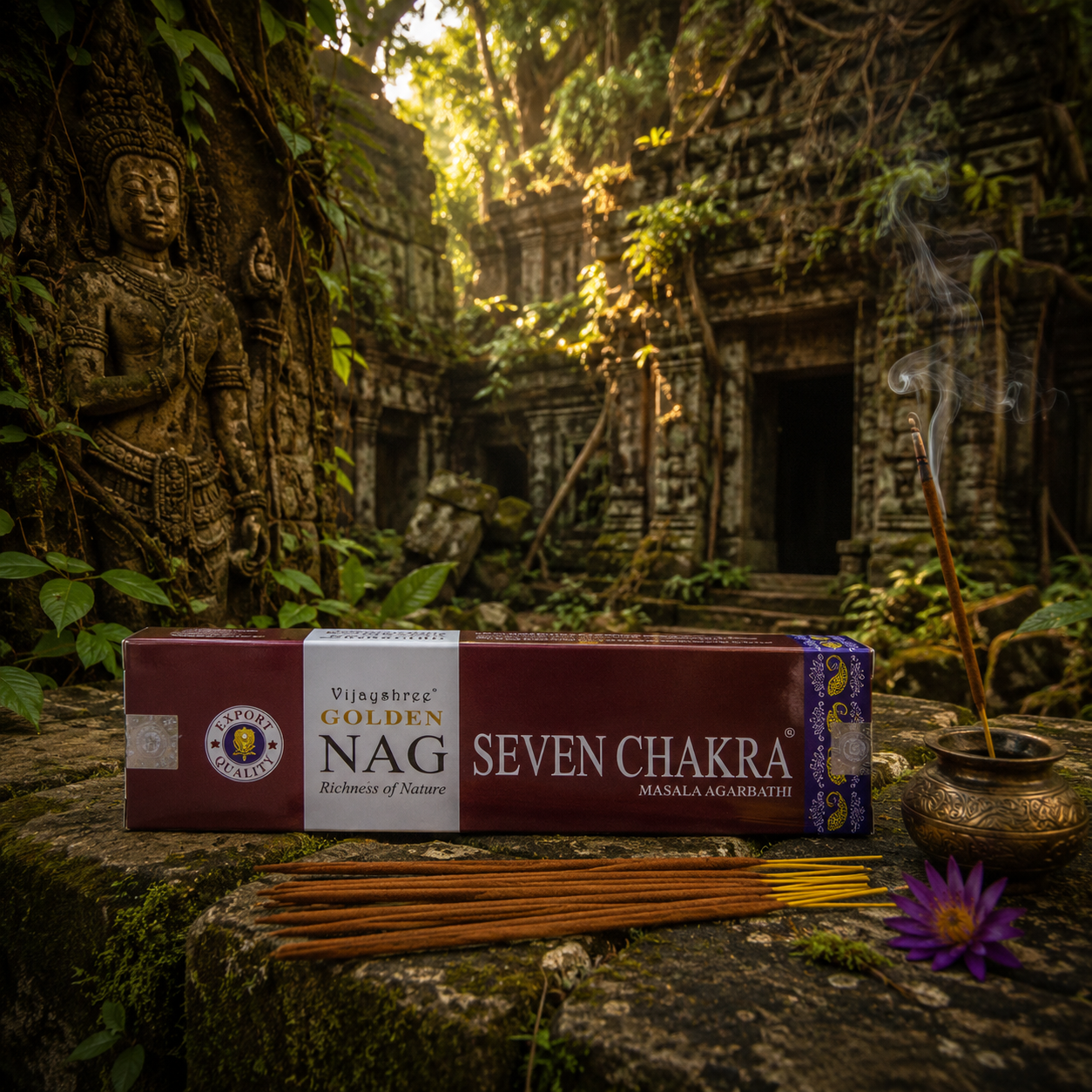 Boîte d'encens Golden Nag Seven Chakra Vijayshree présentée devant un ancien temple hindou en ruine envahi par la végétation tropicale, dans une ambiance mystique propice à la méditation.