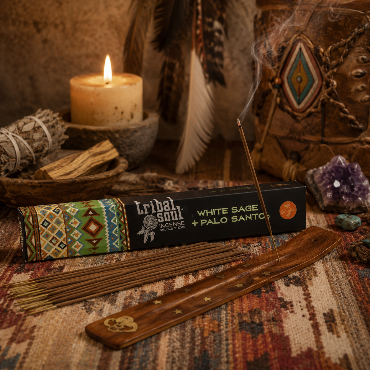 Boîte d'encens Sauge Blanche & Palo Santo Tribal Soul présentée dans une ambiance chamanique avec fagot de sauge, bois de Palo Santo, plumes, cristaux et porte-encens en bois.